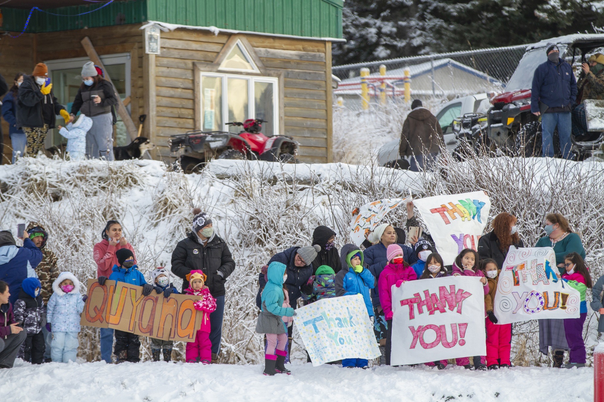 In this photo provided by the Alaska National Guard, residents of the village of Nanwalek, Alaska, greet guardsmen who delivered presents in a CH-47 Chinook helicopter during Operation Santa, Dec. 11, 2020.